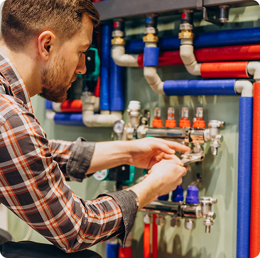 Homme ajustant un robinet dans une installation de chauffage central