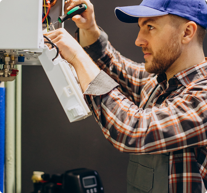 Homme réparant un climatiseur mural avec des outils